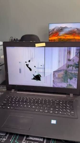 Lenovo laptop with shattered display and ink bleed from impact